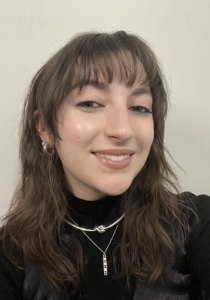 A woman wearing a black shirt, smiling. 